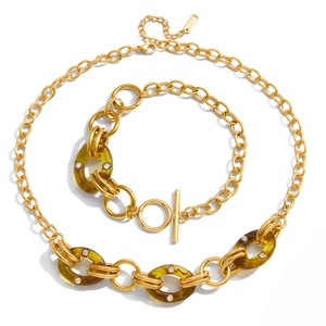 Schmuckset aus goldenem Titanstahl mit grünen Harzgliedern und schimmernden Kristallakzenten