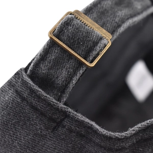 Gros plan sur la boucle en métal bronze vieilli et le coton délavé d'une casquette