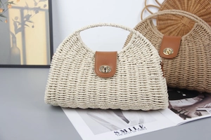 Detail of woven straw handbags in beige and brown with leather flaps and gold twist locks