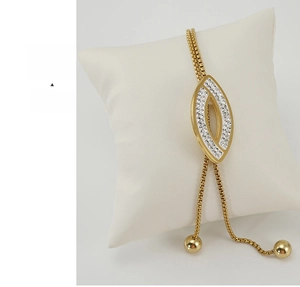 Detail of adjustable gold eye-shaped bracelet featuring sparkling white rhinestones