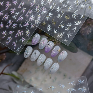 Macro shot of 3D metallic bamboo leaf nail art stickers with aurora and gold accents