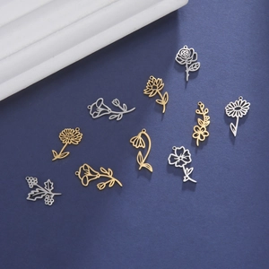 Flat lay of 18K gold and silver hollowed monthly birth flower stainless steel pendants