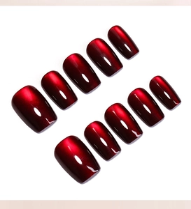 Macro detail of 10-piece dark red cat eye press on nails with shimmering ruby magnetic effect