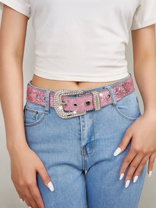 Detail of pink rhinestone studded belt with sequins on light blue denim jeans