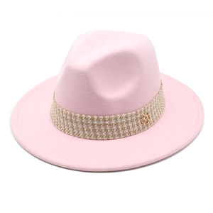 Close-up of pink wool fedora hat featuring a woven band and golden M-logo emblem