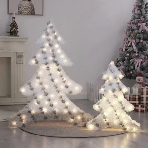 Close-up of two white glowing Christmas tree ornaments in warm LED light setting