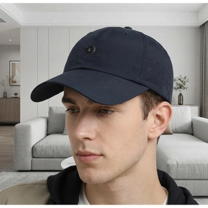 Dettaglio cappello blu scuro con design D traforato al laser ed emblema metallico