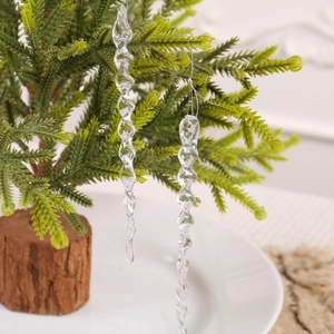 Décorations de Noël en forme de glaçons transparents suspendus sur un sapin festif