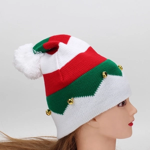 Detail of knitted Christmas hat with red and green stripes, small gold bells and a pompom