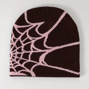 Detail view of the dark brown knitted beanie featuring a pink spider web jacquard pattern