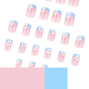 Short square press-on nails with blue French tips and white flower designs