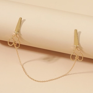 Detail view of gold-tone scissor-shaped collar clips connected by a delicate metal chain
