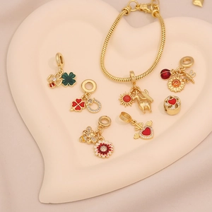 Détail de breloques marguerite et abeille dorées dans un plateau à bijoux en cœur