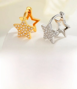 Detailed view of pentagram star huggie hoop earrings in gold and silver with cubic zirconia