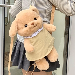 Cute brown plush dog backpack with beige dress worn by a model in a natural setting