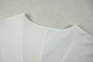 Detailed close-up of the U-neckline and fine stitching on a white slim mini dress