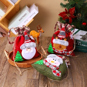 Christmas drawstring gift bags featuring Santa, deer, and snowman designs on wooden surface