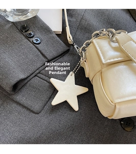 Détail du mini sac carré matelassé blanc cassé avec chaîne argentée et breloque étoile
