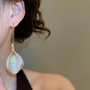 Vue macro de boucles d'oreilles pétales champagne avec finition perlée et crochets dorés