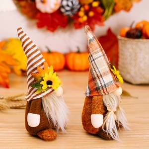 Detail of harvest gnomes with autumn maple leaves and sunflowers for Thanksgiving decor