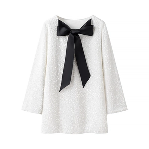 Robe courte blanche à paillettes et manches longues avec un grand nœud noir décoratif