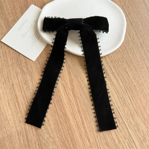 Détail d'un nœud à cheveux en velours noir à longs rubans avec bords en dentelle