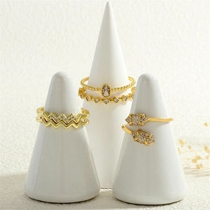 Detailed view of three 18K gold-plated rings with micro-set zircons on white display stands