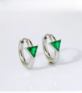 Detail view of silver stainless steel hoop earrings with triangular green zirconia stones