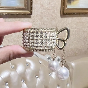 Detail of golden hair claw with pearls and rhinestones, featuring a bow and pearl pendants