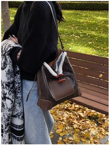 Close-up of leather shearling tote bag with unique wooden horn button closure and front pocket