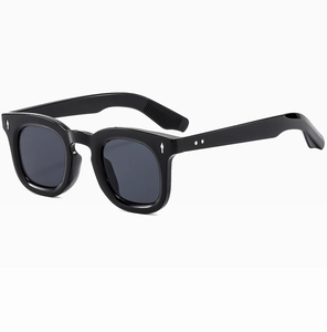 Detail of black round frame sunglasses featuring silver arrow-shaped metal rivets