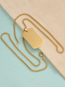 Close-up of golden rectangular dog tag pendant on box chain with a polished metallic finish