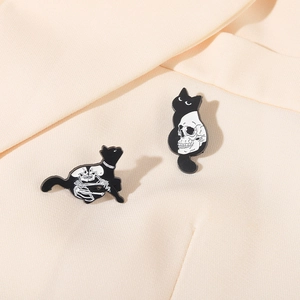 Detailed close-up of dark gothic black cat enamel pins featuring skull and bone patterns