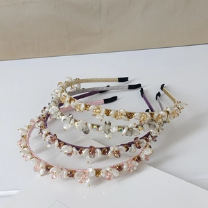 Close-up of four handmade crystal headbands in pink, purple, grey and gold satin