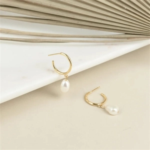Detail of baroque freshwater pearl earrings with golden stainless steel hoop accents