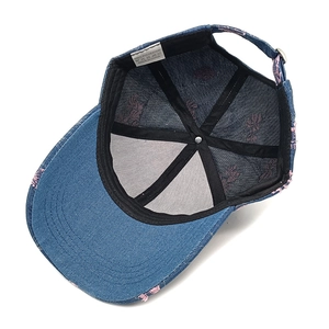 Detailed interior view of a blue denim baseball cap featuring pink floral embroidery