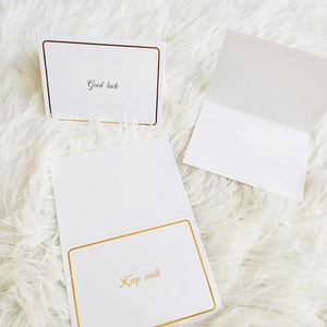 Drei elegante weiße Grußkarten mit Goldprägung und Good Luck Text auf Plüschhintergrund