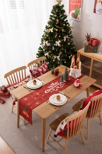 Detailed view of red plaid Christmas table runner with festive bells and snowflakes