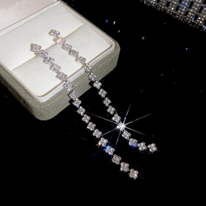 Macro shot of silver tassel earrings with square rhinestones and starburst lighting