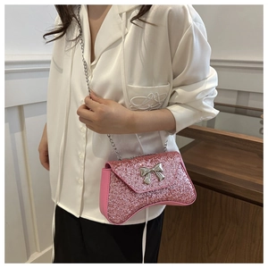 Pink sequined evening bag with silver bow buckle and chain strap shown on shoulder