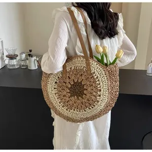 Close-up of circular woven straw shoulder bag with leather straps and paper rope texture