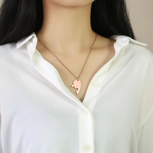 Close-up of heart-shaped puzzle pendant necklace in rose gold finish on a model