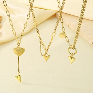 Close-up of golden double-layered heart necklaces featuring tassel and Y-shape designs