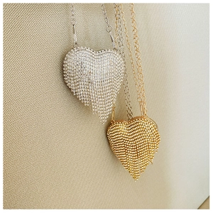 Detailed view of silver and gold heart-shaped mini evening bags with rhinestones and tassels