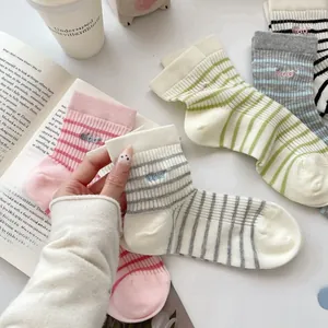 Close-up of pastel striped cotton socks with embroidered miao letter and ribbed cuffs