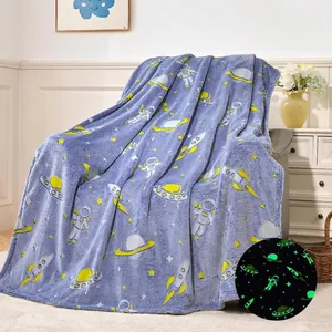 Detail of blue glow-in-the-dark flannel blanket with space astronauts and rockets patterns