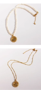 Detail of vintage coin pendant necklaces with freshwater pearls and gold satellite chain
