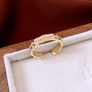 Macro detail of wave-shaped 14K gold plated ring with micro-pave cubic zirconia settings