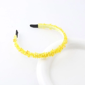 Detail of yellow floral headband with intricate crystal beadwork on white background
