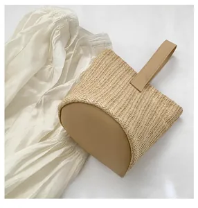 Detail view of the reinforced synthetic leather base and woven straw texture of bucket bag